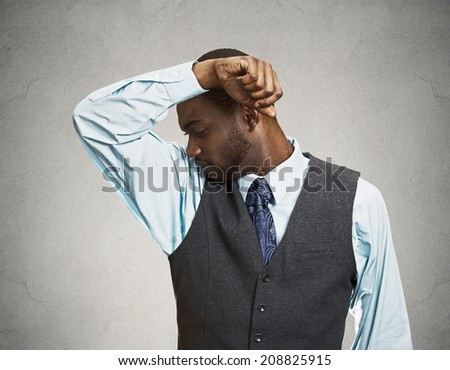 Closeup portrait young Man, Smelling sniffing Armpit, something Stinks very bad, foul Odor situation isolated grey, black background. Negative human emotions, facial expressions, feeling body language