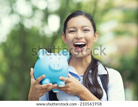 Closeup portrait happy, smiling business woman, bank employee holding piggy bank, isolated outdoors green trees background. Financial savings, banking concept. Positive emotions, face expressions