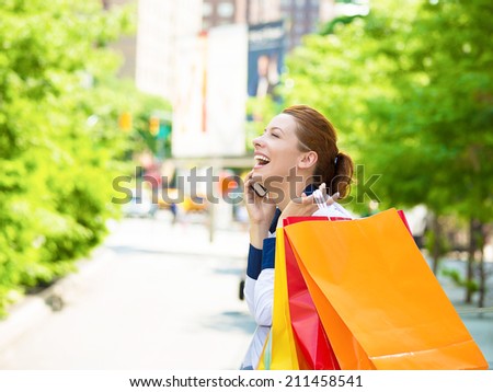 Shopping woman in New York City. Beautiful, happy, summer shopper holding shopping bags, smiling talking on phone, yellow taxi cab in background. Positive emotions. Caucasian model in Manhattan, USA.