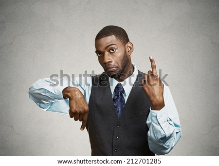 Portrait confused young business man pointing in two different directions, not sure which way to go in life, hesitant to make decision isolated grey background. Emotion facial expression body language