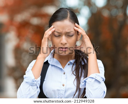 Closeup portrait unhappy young business woman hands on head stressed bothered by mistake having bad headache migraine isolated outdoor park background. Negative human emotion facial expression feeling