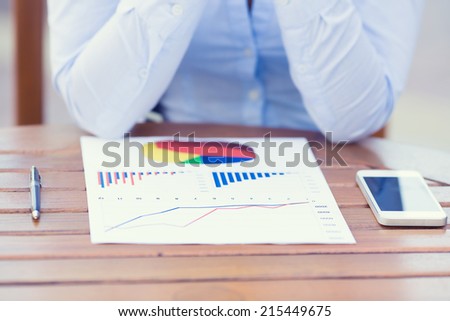 Closeup cropped image business woman hands, executive sitting at table in front of financial report document with graph, charts, diagram ready to discuss company results, profits. Stock market concept