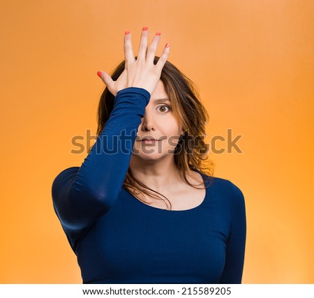 Portrait middle aged woman realizes mistake, slapping hand on head to say duh, isolated  orange background. Negative emotions, facial expression, feelings, body language,
