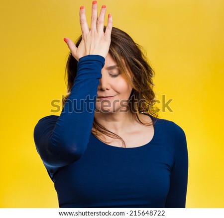 Portrait sad middle aged woman realizes mistake, regrets, slapping hand on head to say duh, isolated yellow background. Negative emotions, facial expression, feelings, body language, reaction