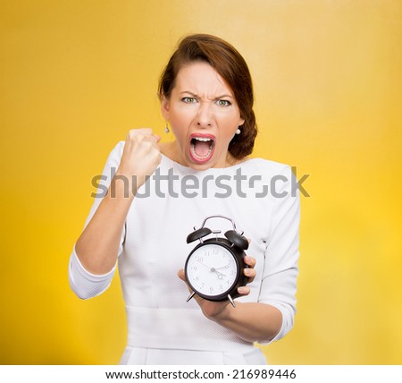 Punctuality. Be on time! Portrait angry demanding boss woman screaming manager holding alarm clock requesting employees not be late push project deadline isolated yellow background. Negative emotion