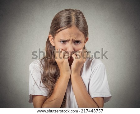 Scared, shy. Closeup portrait nervous anxious stressed teenager girl biting fingernails looking anxiously craving something, afraid isolated grey wall background. Negative emotion facial expression