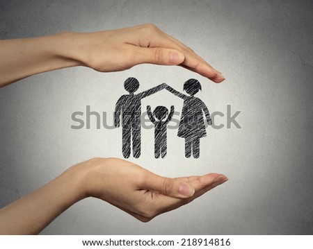 close up of woman\'s hands protecting happy family, mother, father, child. Family abstract in palms on grey wall background. Safe childhood, parenting. Love care compassion safety secure future concept