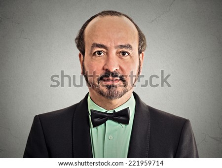 headshot portrait mature gentleman handsome man in elegant black suit wearing bow tie isolated on grey wall background. Positive face expression handsome man in elegant black suit