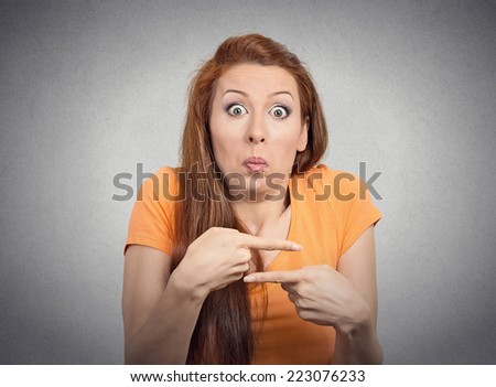 Portrait confused young woman pointing in two different directions not sure which way to go in life isolated grey wall background. Negative emotion facial expression feeling body language perception