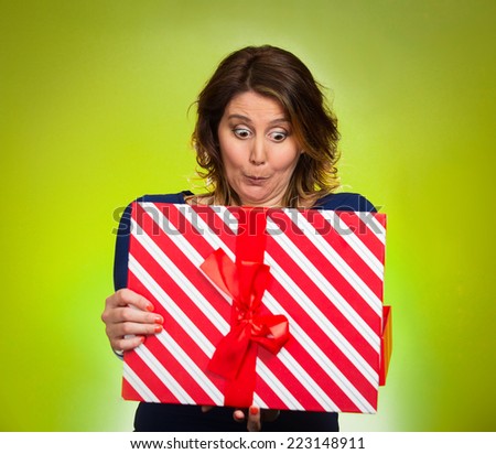Portrait happy excited middle aged woman opening red gift box, very pleased surprised grateful with what she received isolated green background. Positive emotion facial expression feeling attitude