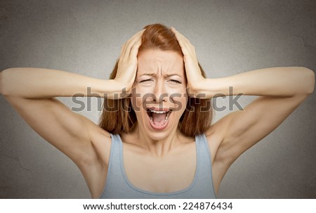 Closeup portrait stressed woman covers ears with hands yelling screaming with temper tantrum isolated grey wall background. Negative human emotions, facial expressions, feelings reaction attitude