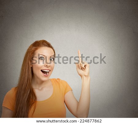 Closeup portrait intelligent excited young woman who just came up with idea aha isolated grey wall background with copy space. Positive human emotion facial expression feeling perception body language