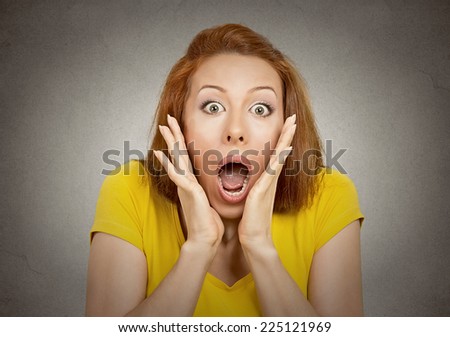 frightened shocked woman looking at camera isolated on grey wall background. Human emotion facial expression body language unexpected reaction