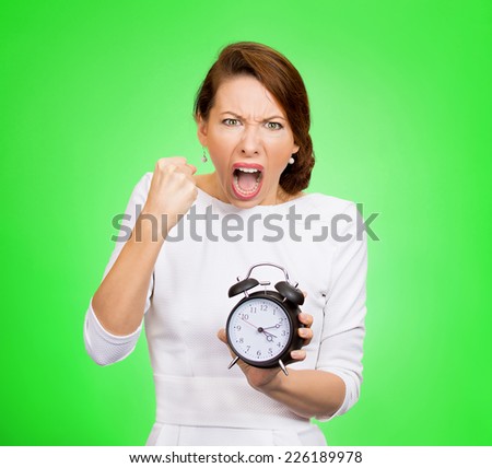 Angry boss with alarm clock. Punctuality Be on time! Portrait demanding woman screaming holding alarm clock requesting employees not be late push project isolated green background. Negative emotion