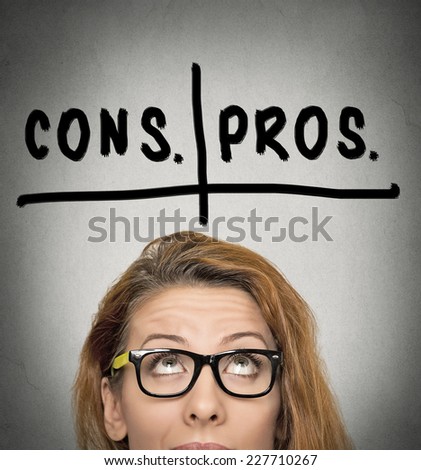 pros and cons, for and against argument concept. Thinking young business woman with glasses looking up isolated on grey wall background. Face expression, emotion, feeling, perception, vision, decision
