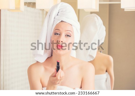 Portrait young woman in hotel bathroom smiling with towel on her head after bath refreshing herself applying makeup. Positive face expression emotion feeling. Healthy life wellness happiness concept