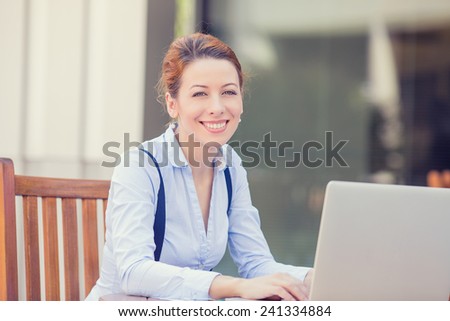 Portrait young happy smiling woman working on computer laptop outside outdoors corporate office isolated city background college campus. Positive human face expression, emotion, life success concept