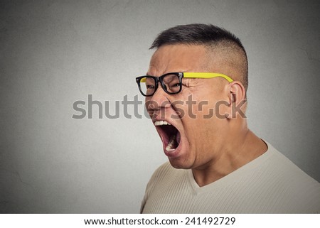 Side profile portrait bitter mad displeased pissed off angry grumpy middle aged man with glasses open mouth screaming yelling isolated grey background. Negative human emotion facial expression feeling