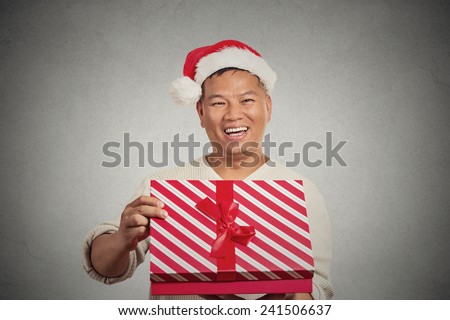 Closeup portrait happy excited surprised middle aged man opening unwrapping red gift box isolated grey wall background, enjoying his present. Positive human emotion facial expression feeling attitude