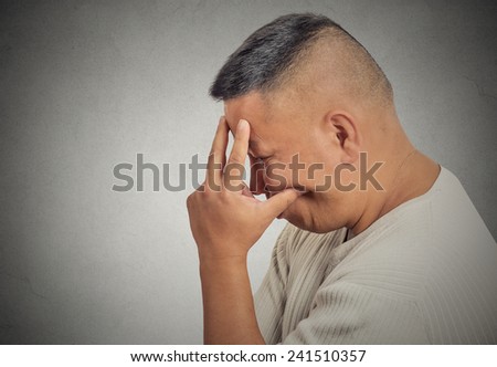 Closeup side profile portrait sad bothered stressed middle aged man holding head with hand really depressed about something isolated grey background. Negative human emotion facial expression feeling