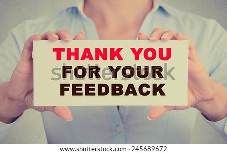 Business woman hands holding white card sign with Thank you for your feedback text message isolated on grey wall office background. Retro instagram style image