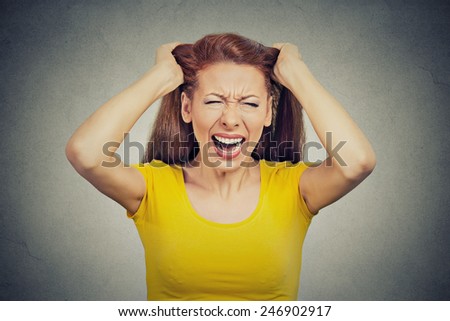Closeup portrait headshot stressed young housewife, woman, employee, worker having bad day too many things to do tension headache isolated grey wall background. Human face expression emotion reaction