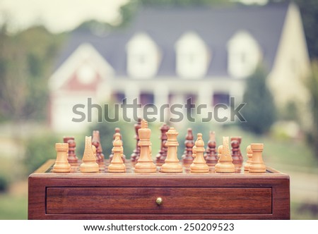 Real estate sale, home savings, loans market concept. Housing industry mortgage plan and residential tax saving strategy. Chess game figures isolated outside home background.