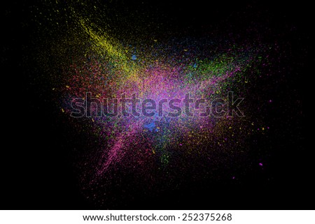 Freeze motion of colorful powder paint exploding isolated on black dark background. Abstract design of color dust cloud. Particles explosion screen saver, wallpaper, brush
