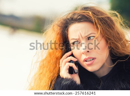 Closeup portrait upset sad, skeptical, unhappy, serious woman talking on phone, standing outdoor. Negative human emotions, facial expressions, feelings, life reaction. Bad news perception
