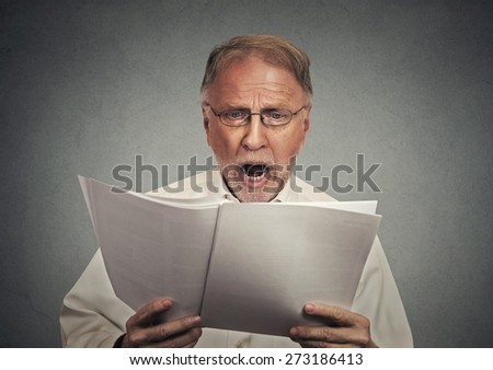 Closeup portrait surprised businessman reading documents isolated on grey wall background