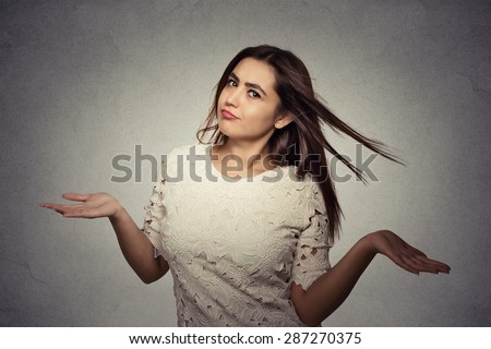 Portrait annoyed looking woman arms out shrugs shoulders who cares so what I don\'t know isolated on gray background. Negative human emotion, facial expression body language life perception attitude