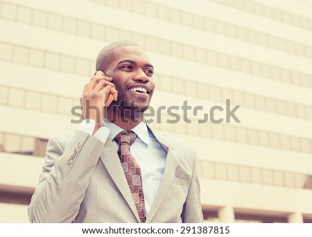 Portrait businessman talking on cell phone outside on a background of corporate office