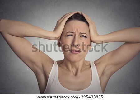 Closeup portrait stressed sad young woman overwhelmed having headache about to cry, hands on head