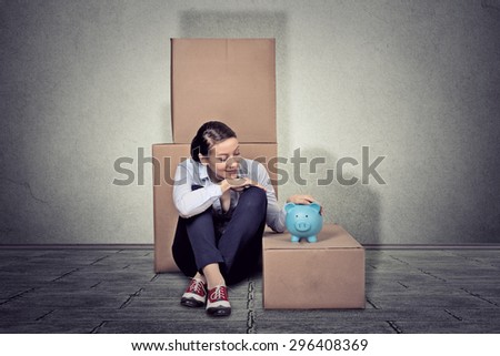 Portrait young happy woman sitting on the floor with many boxes, moving out