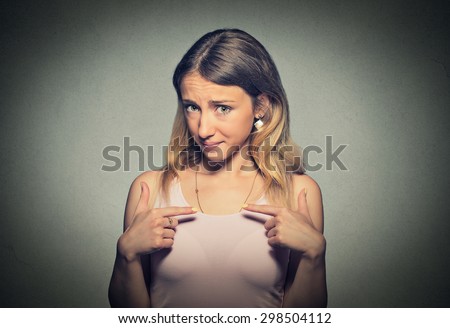 Portrait of mad angry, unhappy, annoyed young woman, getting mad asking question you talking to me, you mean me? Isolated on gray wall background. Negative emotions, facial expressions