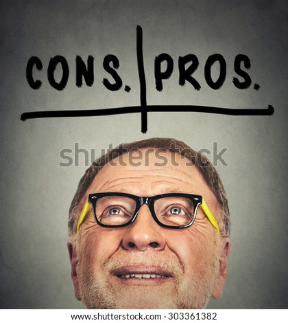 pros and cons, for and against argument concept. Closeup portrait of thinking old man with glasses looking up isolated on gray wall background with copy space
