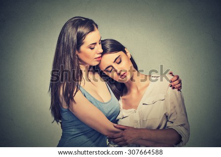 Portrait two women. Sad unhappy young woman being consoled by her friend. Friendship help support and difficult times concept. Human emotions feelings