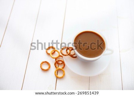 White coffee cup with rich coffee  on a white wooden table