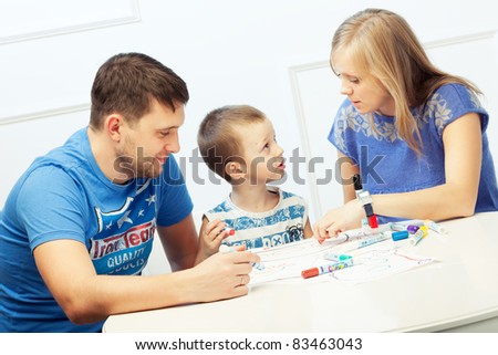 Young parents drawing at the table with their son