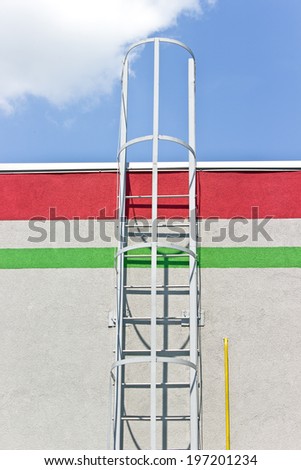 Safety metal ladder to the roof and  blue sky