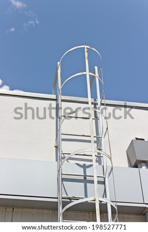 Safety metal ladder to the roof and  blue sky