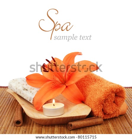Spa setting with candle, flower, towel, cinnamon and natural soap over white background