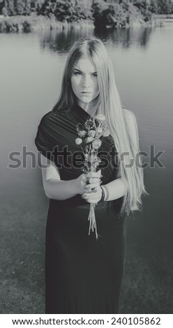 unusual gothic girl with long red hair and flowers in the black and white