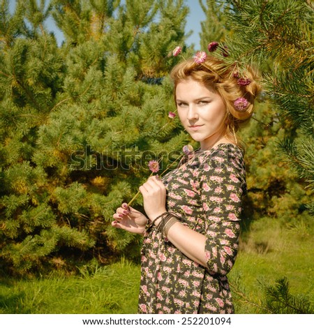portrait of wonderful woman in fir-tree wood with flowers spring