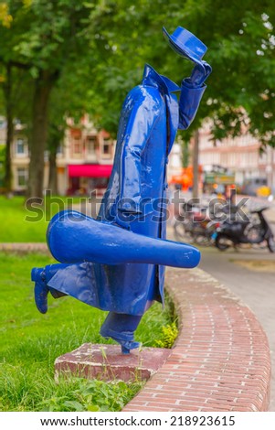 Amsterdam, Netherlands - August 06, 2014: Modern sculpture by an unknown author Running man with a violin or the Invisible Man in the street Tweede Marnixplantsoen.