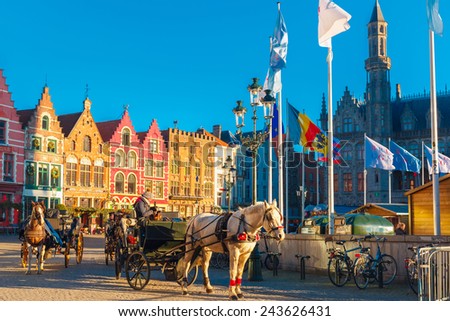 Bruges, Belgium - December 28, 2014: Horse carriage waiting tourists at Christmas morning on Grote Markt square of Brugge. Belgian city of Bruges is UNESCO world heritage listed for its medieval