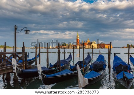 Gondolas moored by Saint Mark square with San Giorgio di Maggiore church in the background in Venice lagoon after the storm, Italia