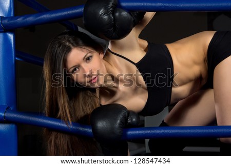 Sports Boxing Woman in black box gloves in fitness gym on a black background