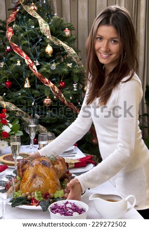 Woman serve Roasted turkey chicken for family christmas new year dinner celebration on fir tree ornament decoration background
