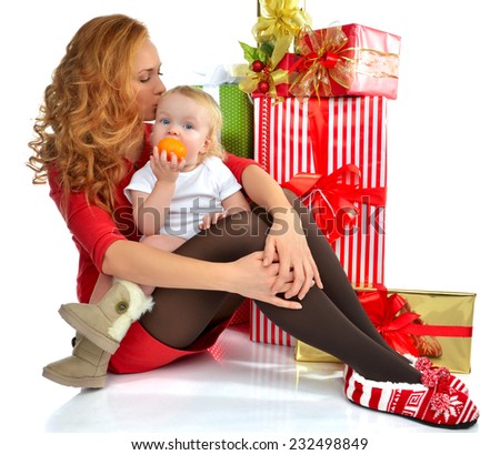Christmas new year concept. Happy young woman with wrapped christmas presents gifts and infant child baby toddler with mandarine isolated on a white background